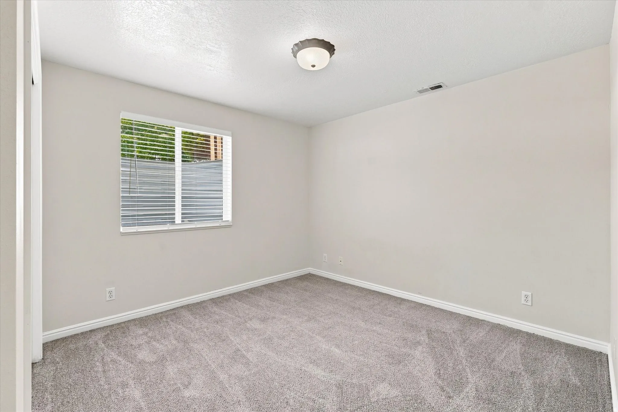 Light gray wall paint complemented by white trim and neutral carpeting