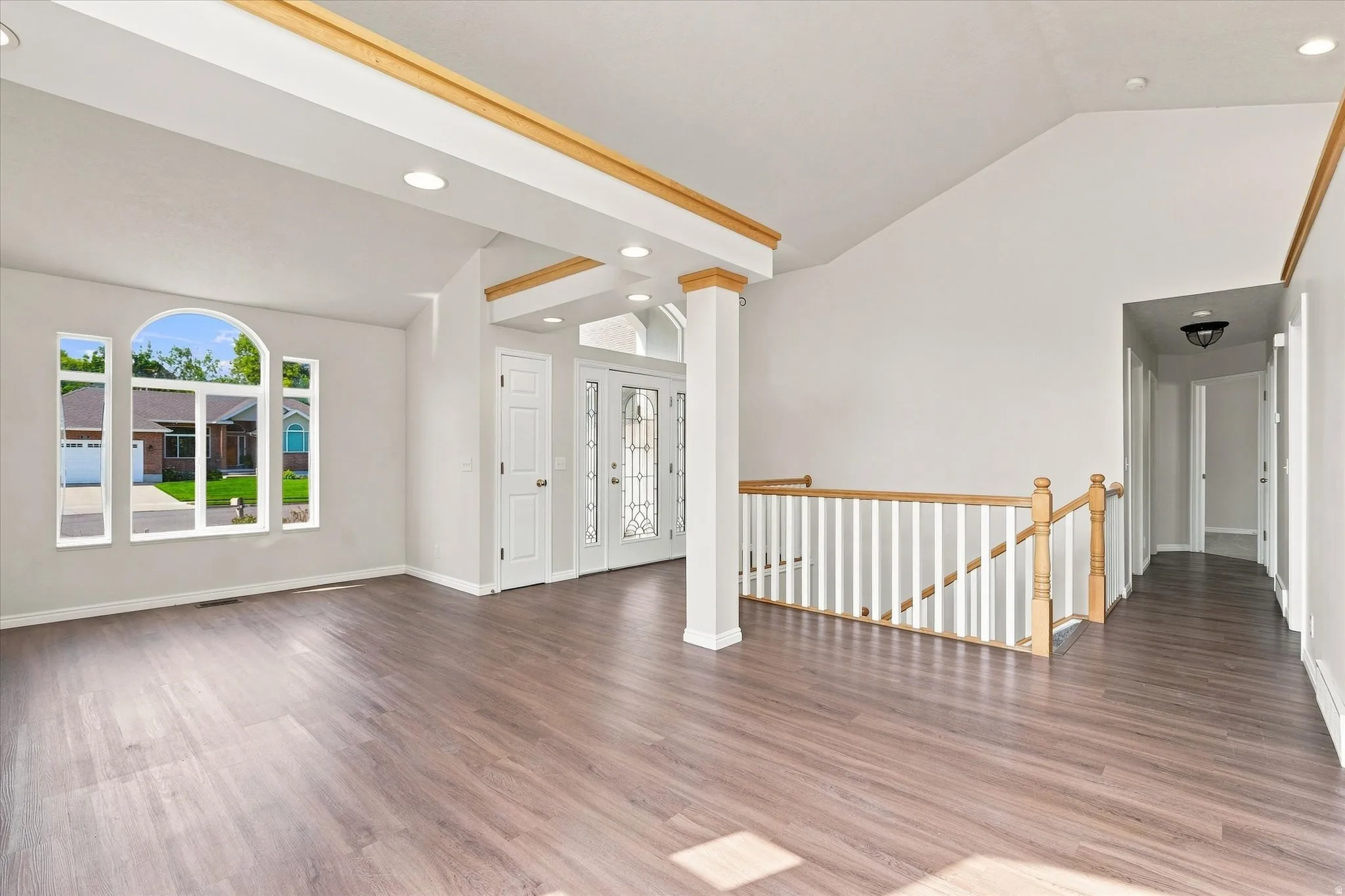 Vaulted ceilings with wood-trim accents, recessed lighting, and wood-finish flooring