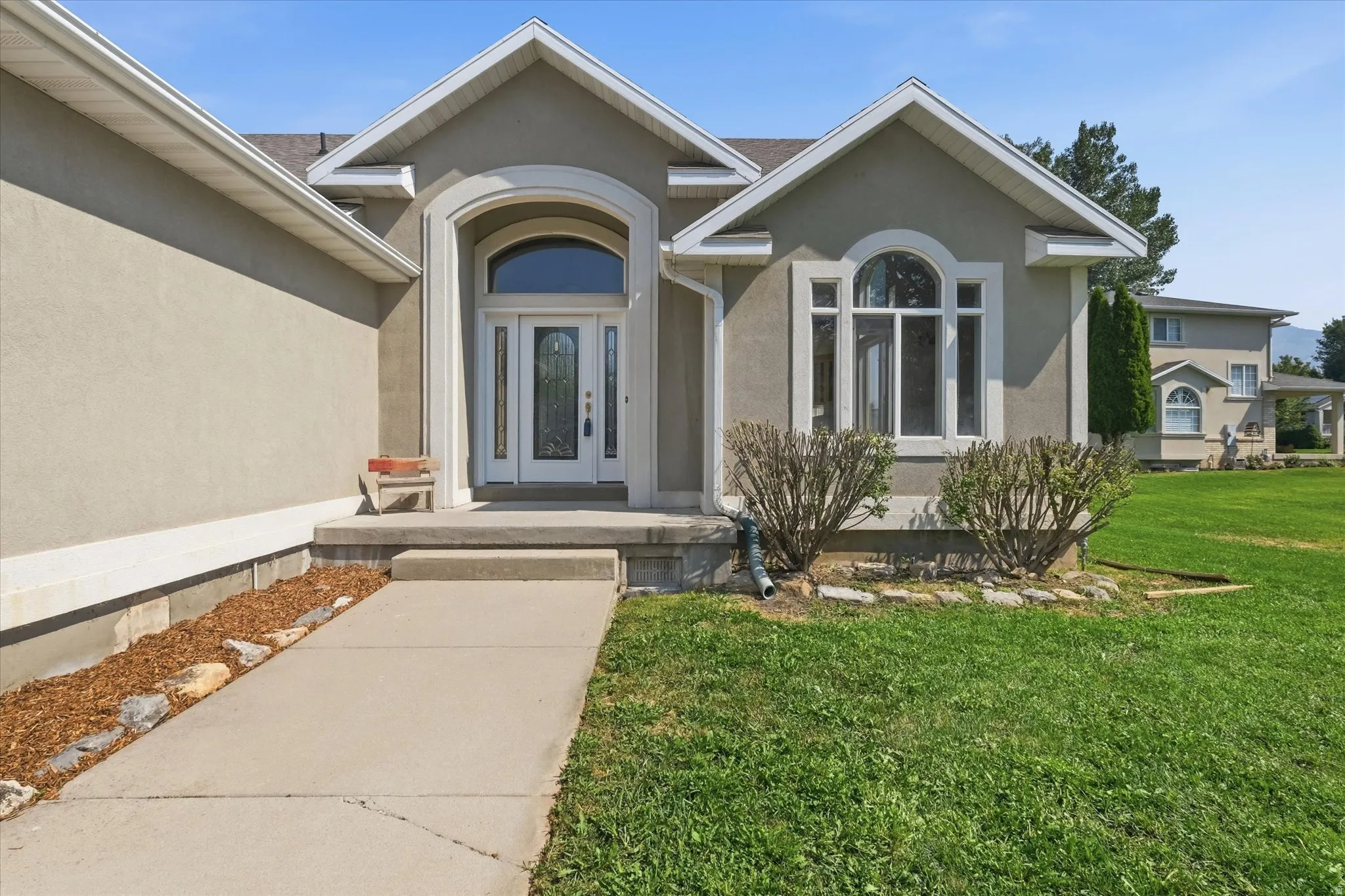 Stucco exterior with an arched entry, a decorative glass front door, and an arched window