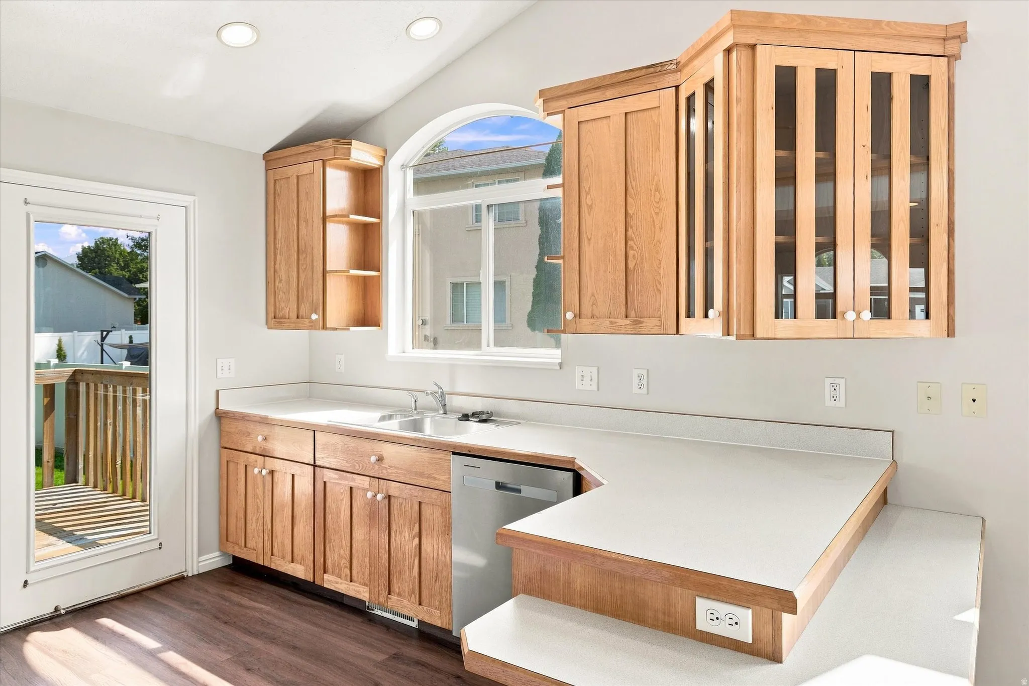 Wood-finish flooring with a white-paneled door leading to a wood deck