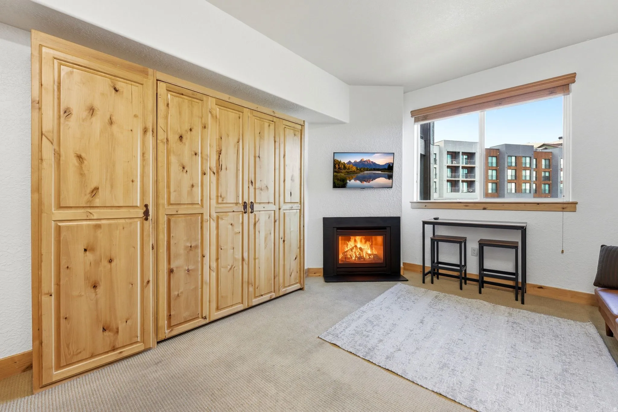 Extensive wood-finish cabinetry along one wall, complemented by a corner-set electric fireplace