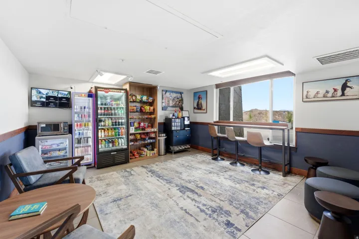 Open common area featuring a wide window with a built-in bar table, modern pendant lighting, and a patterned area rug
