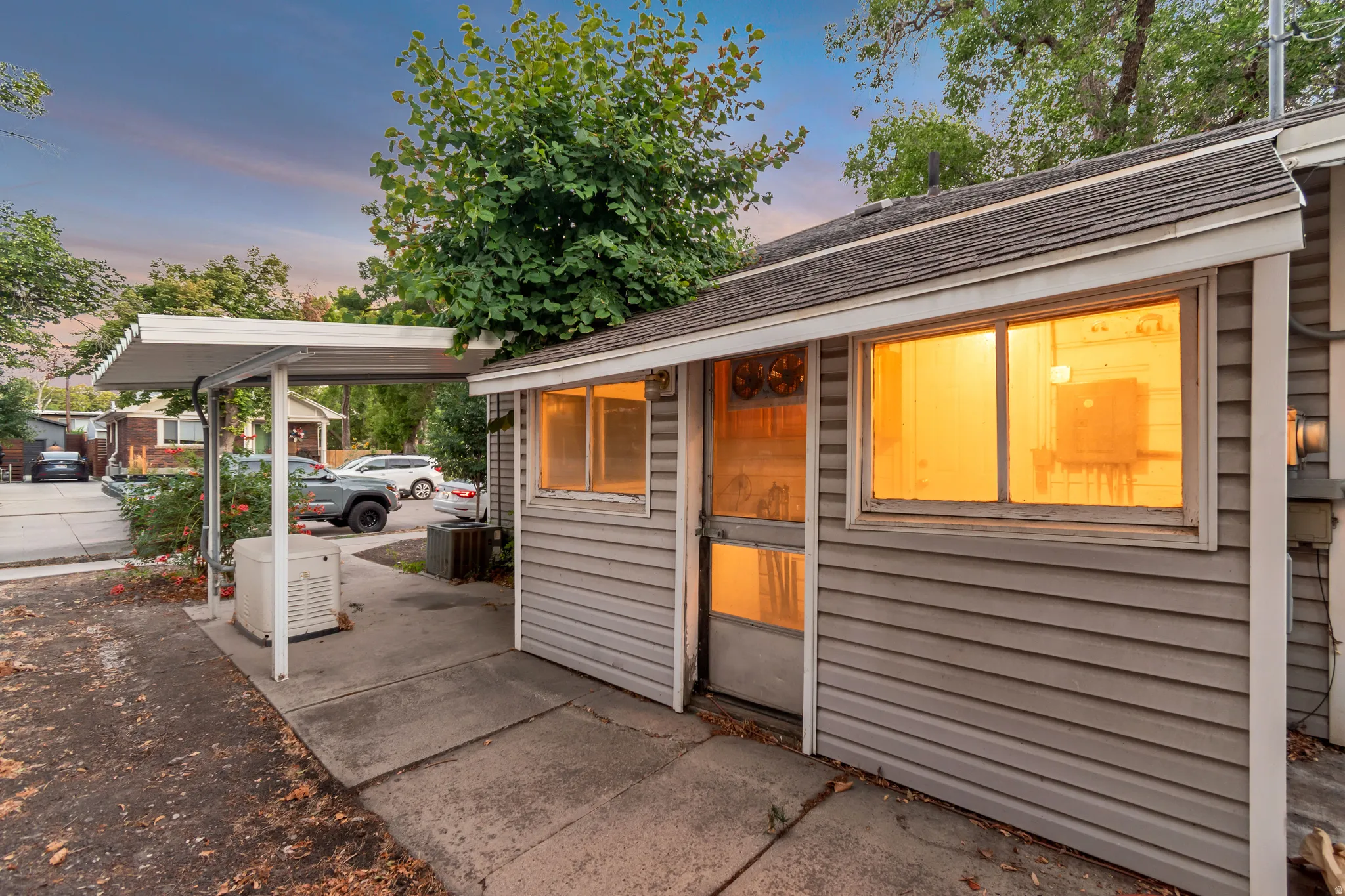 Exterior featuring horizontal siding, a covered carport, and concrete paving