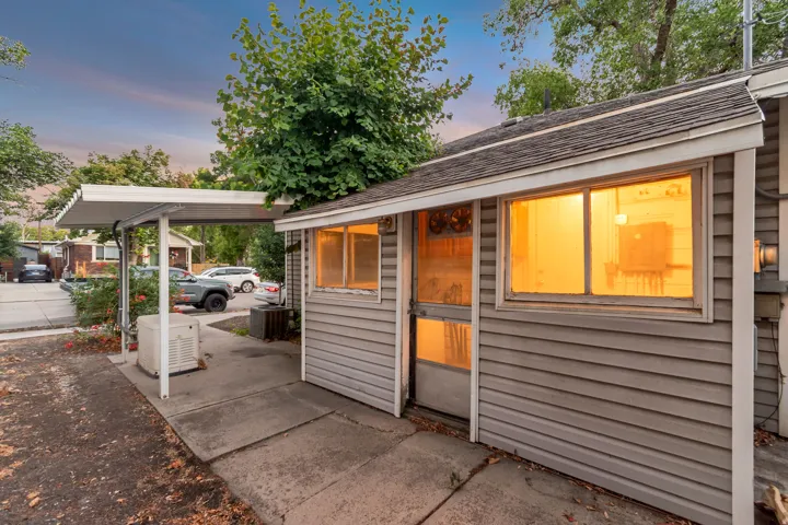 Exterior featuring horizontal siding, a covered carport, and concrete paving