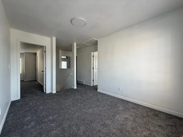 Spacious room featuring gray carpet flooring and neutral wall tones