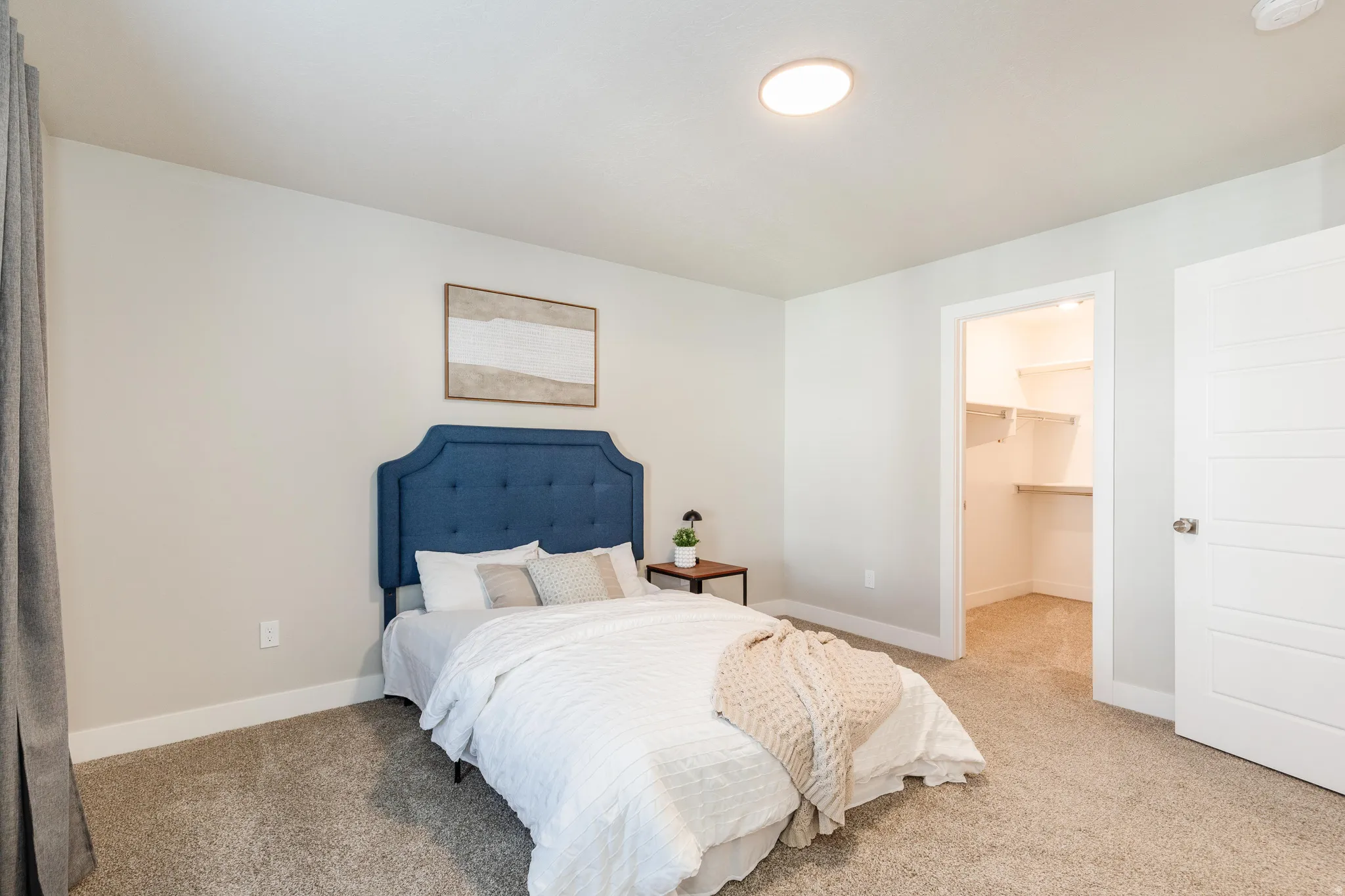 Carpeted bedroom featuring neutral wall tones and white baseboards