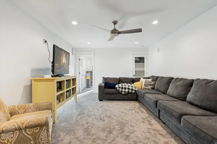 Spacious room featuring neutral carpet flooring, recessed lighting, and a ceiling fan