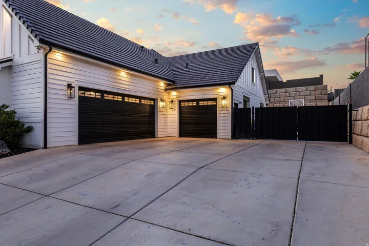 Spacious concrete driveway featuring a private entry gate