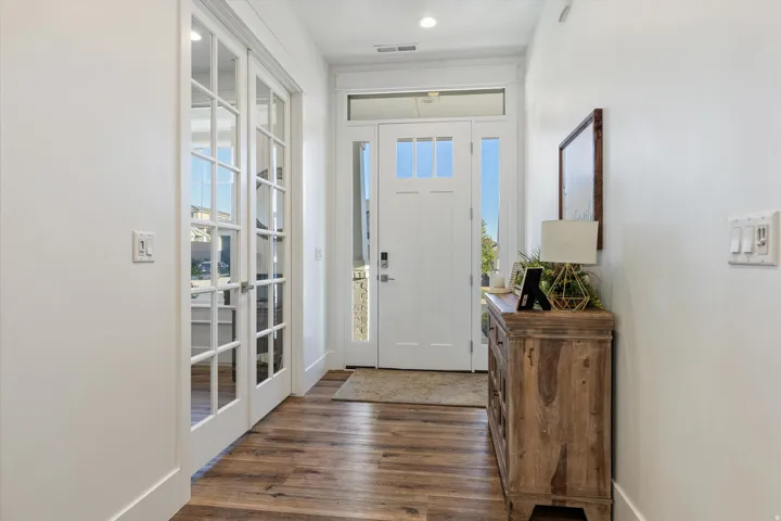 Inviting entry featuring wood-finish flooring, white trim, and recessed lighting