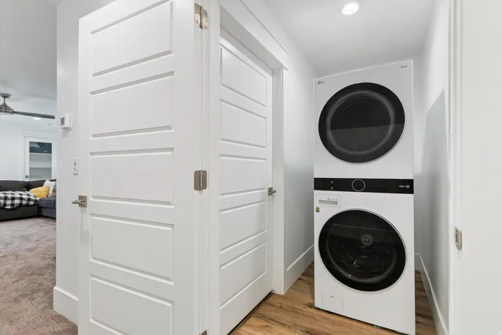Compact laundry area featuring a stacked washer and dryer unit