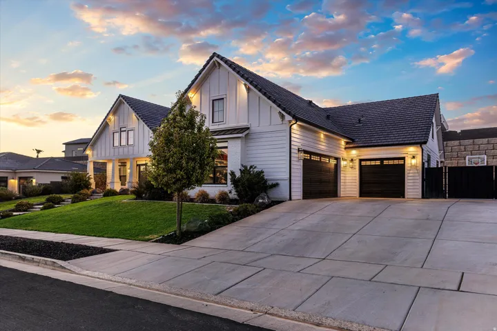 Modern farmhouse-style exterior featuring white horizontal siding and dark gabled roofs