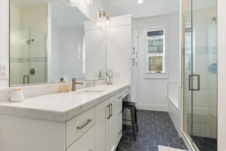 Bathroom featuring a wide vanity with a light-toned countertop, integrated sink, and an extensive mirror