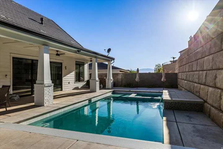 Rectangular swimming pool with integrated spa and waterfall feature