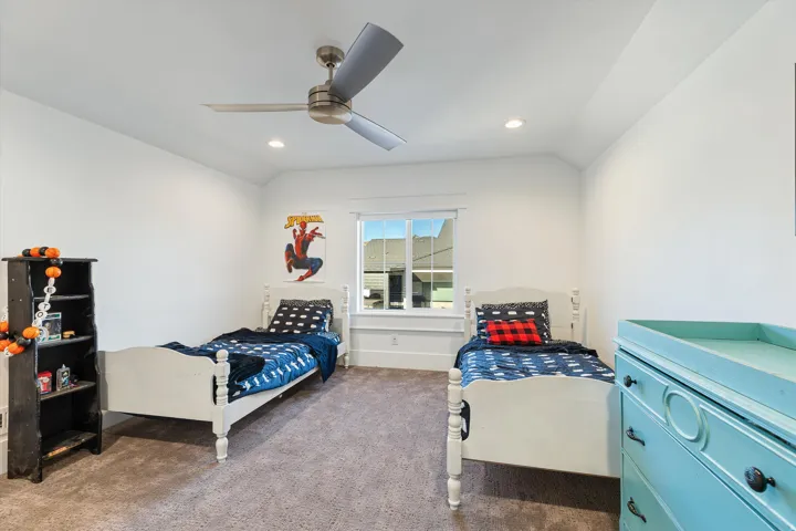 Bright bedroom featuring a sloped ceiling, recessed lighting, and a modern ceiling fan
