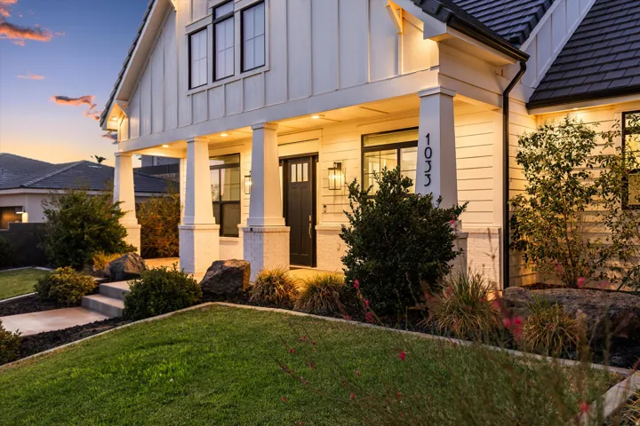 Inviting front entrance with board and batten siding, substantial columns, and a dark paneled door