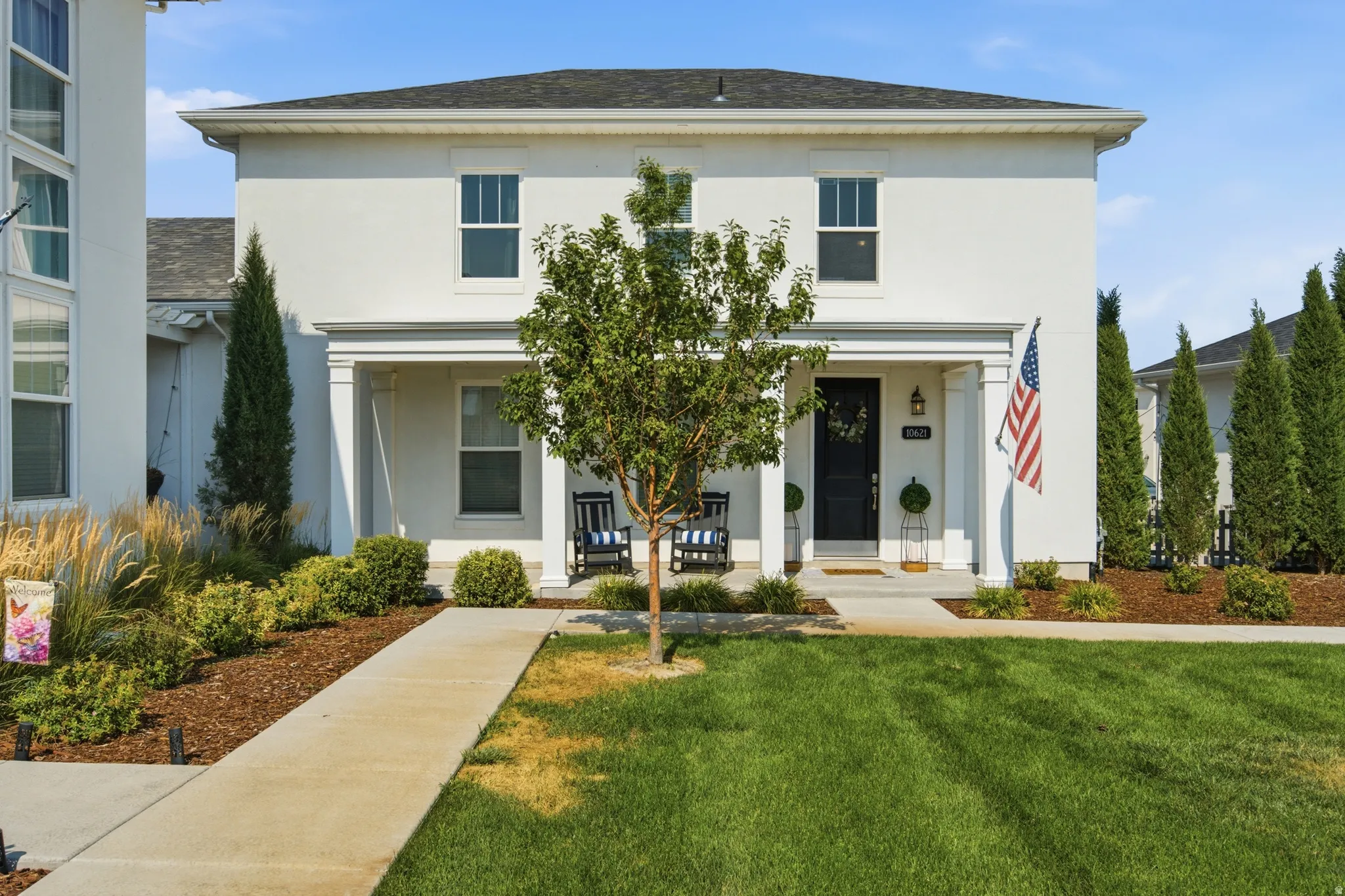 White stucco exterior with a covered porch featuring square columns