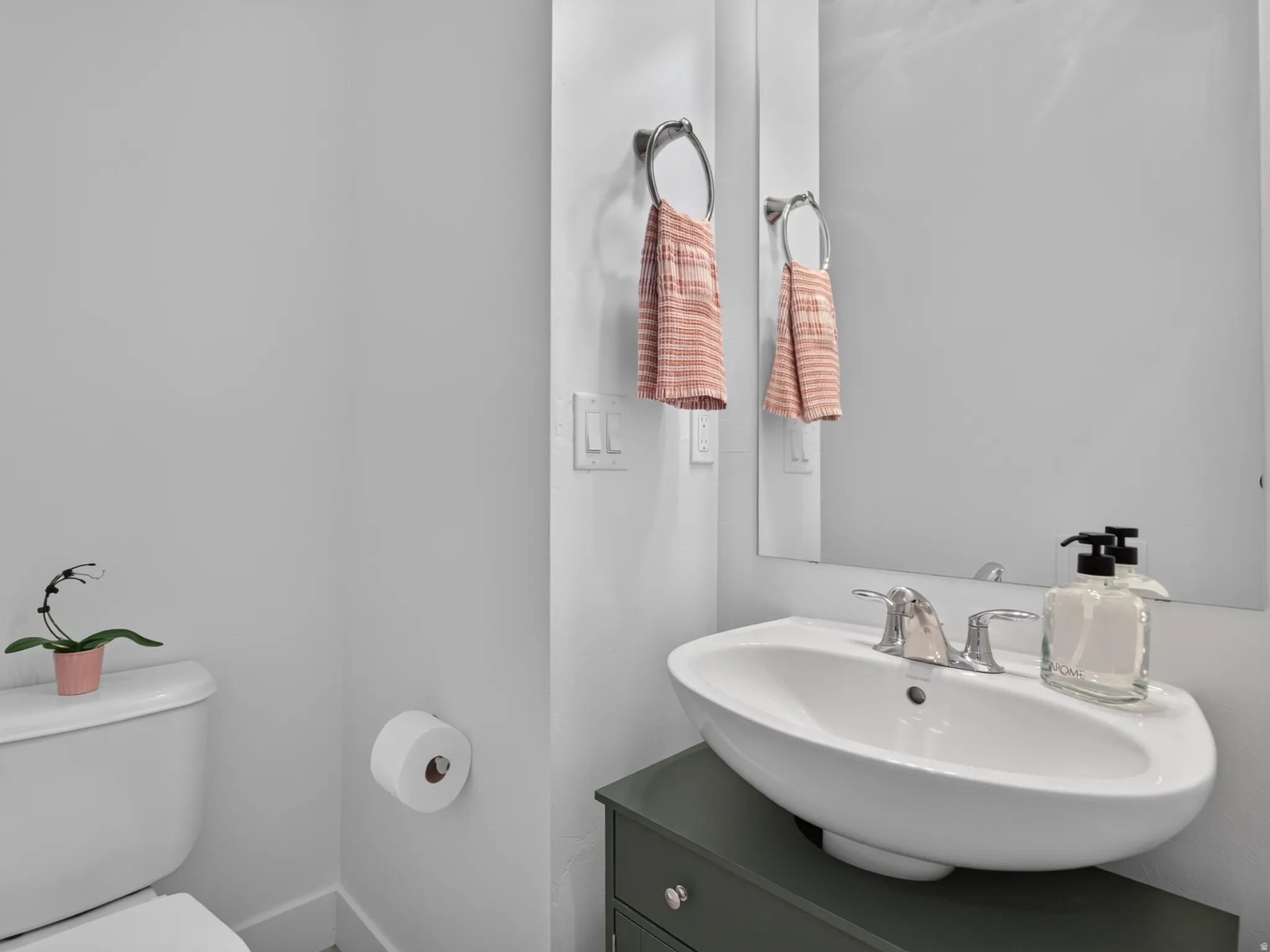 Contemporary bathroom featuring a vessel sink, chrome faucet, vanity with cabinet storage, and a wall-mounted mirror