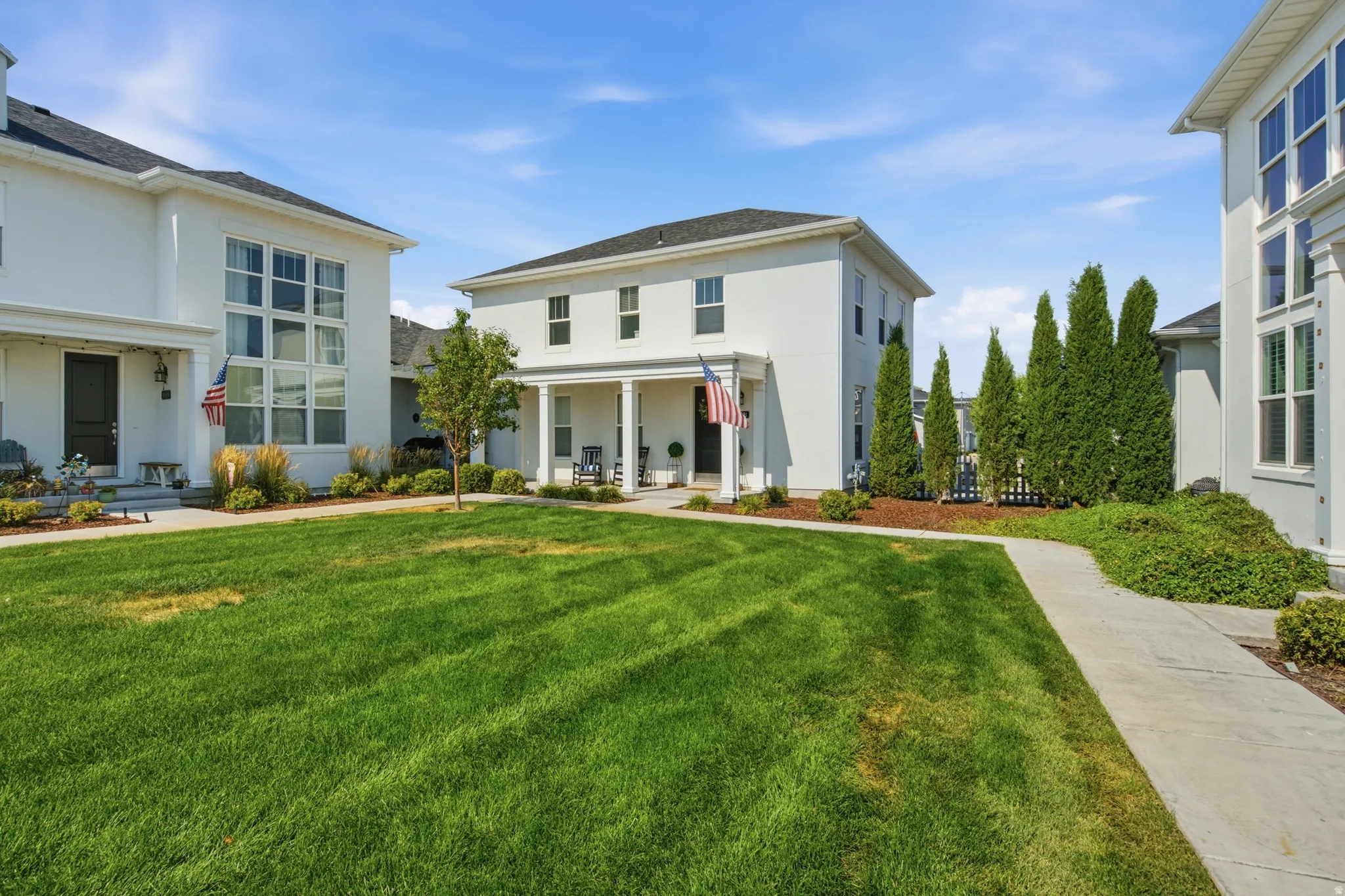 White stucco exterior with a covered front porch and columns