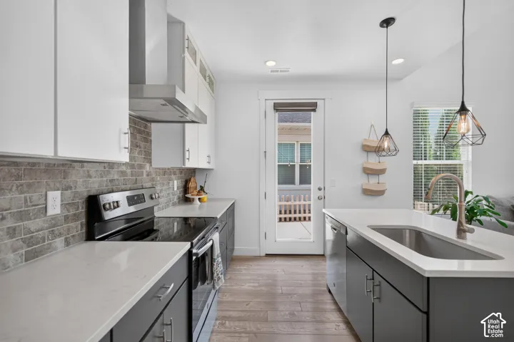 Modern kitchen featuring two-tone cabinetry, light-toned countertops, and a subway tile backsplash