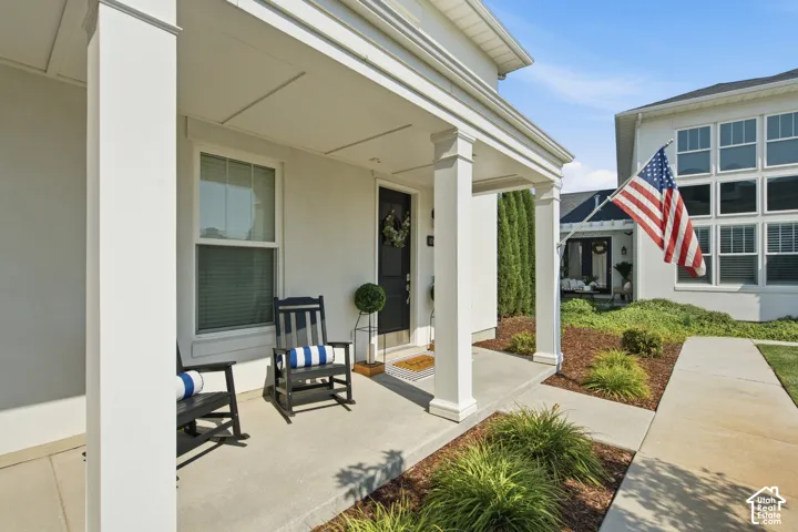 Covered porch entrance featuring white columns and a black front door