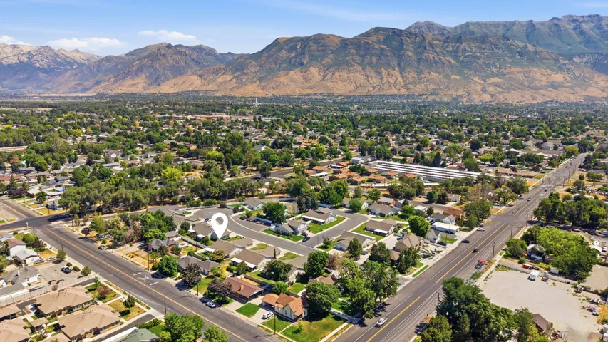Aerial perspective of a residential neighborhood with a prominent mountain range backdrop