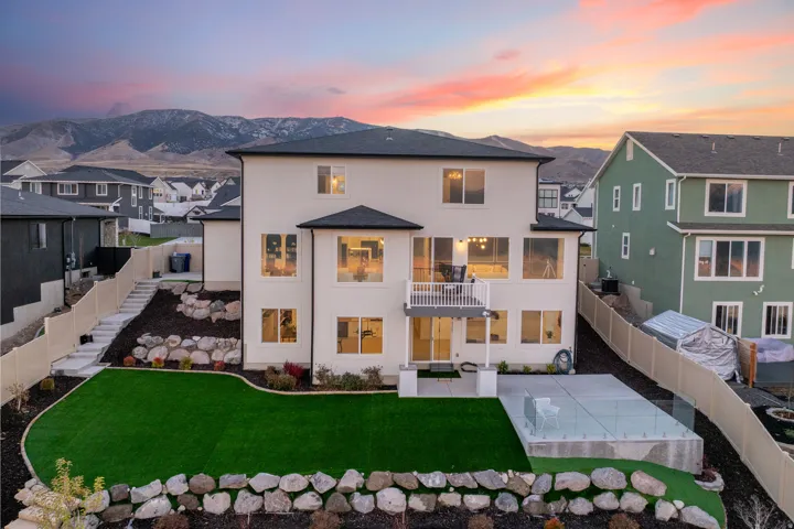 Rear exterior featuring a multi-level design with a balcony and ground-level patio