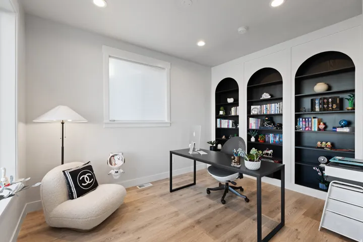 Recessed lighting illuminates the room, featuring built-in arched shelving with contrasting dark interiors
