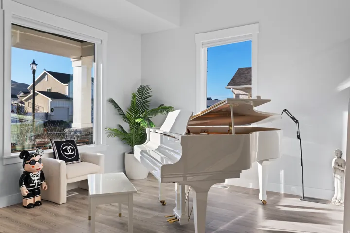 Bright interior space featuring light wood-finish flooring and large windows with white trim
