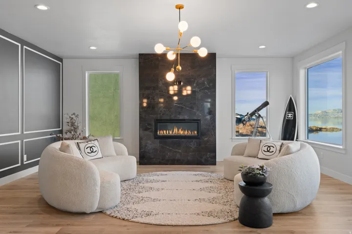Spacious interior featuring a dark stone fireplace with an integrated linear firebox, light wood-finish flooring, and recessed ceiling lights