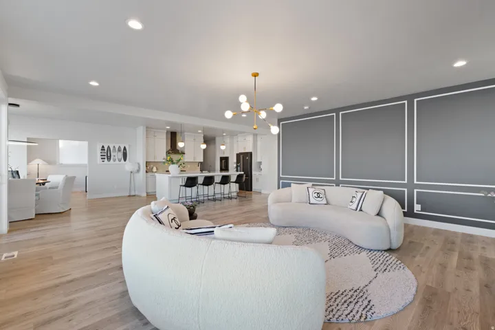 Spacious open-concept living area featuring light wood-finish flooring and recessed lighting