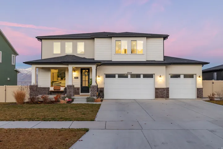 Contemporary two-story exterior with a covered front porch, a two-car garage, and a concrete driveway