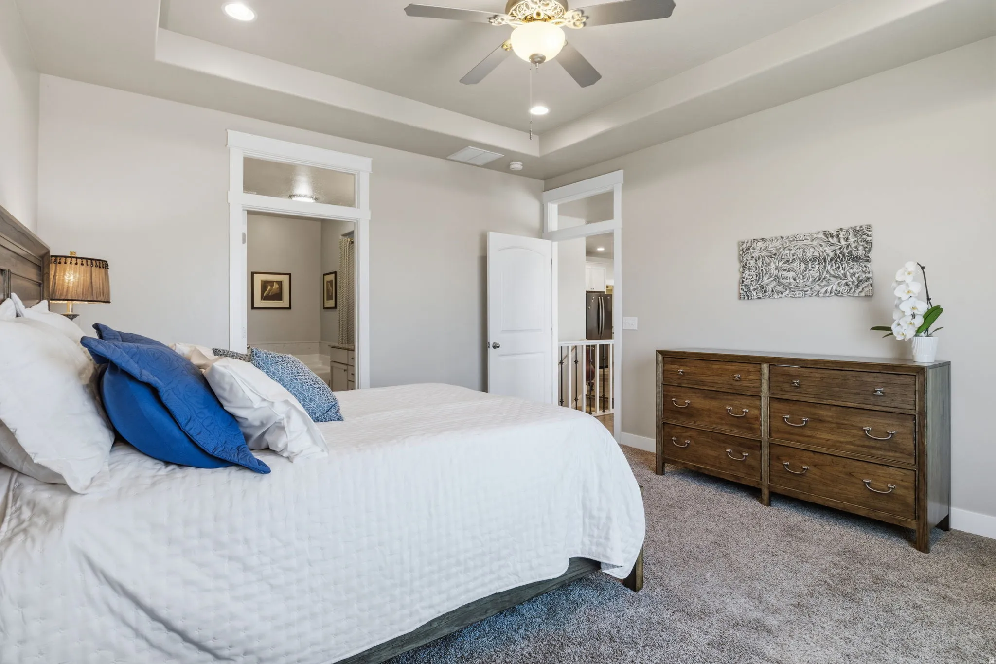 Spacious room featuring a tray ceiling with recessed lighting and a ceiling fan, neutral wall tones, and plush carpet flooring.  Picture your things in this peaceful room.