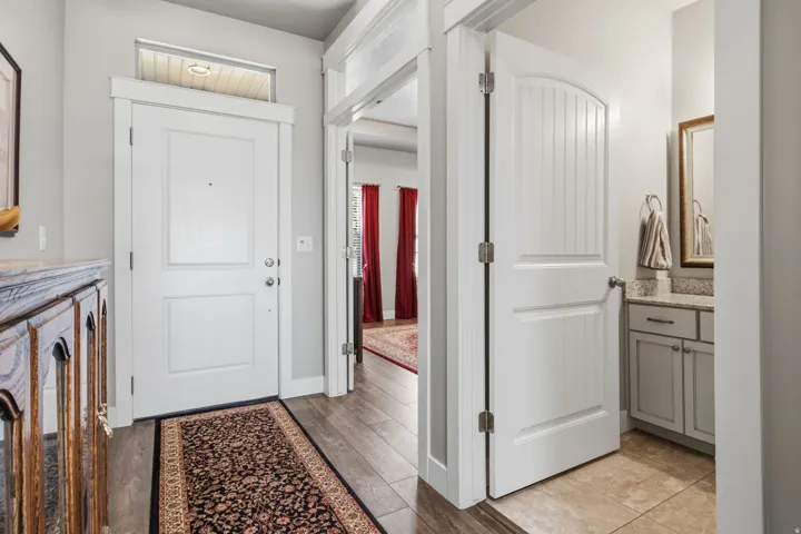 Entryway featuring wood-finish flooring and a white paneled front door with an overhead transom window.  The inside connecting walls are built with soundproofing.  No noise is GREAT!!!