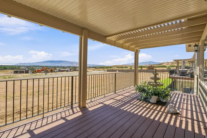 Great for outside dining or just curling up with a good book.  This covered balcony features a slatted pergola roof, composite decking, and black metal railings