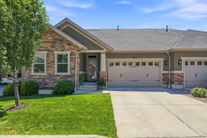 CRAFTMAN STYLE Contemporary exterior featuring stone facade accents and neutral stucco