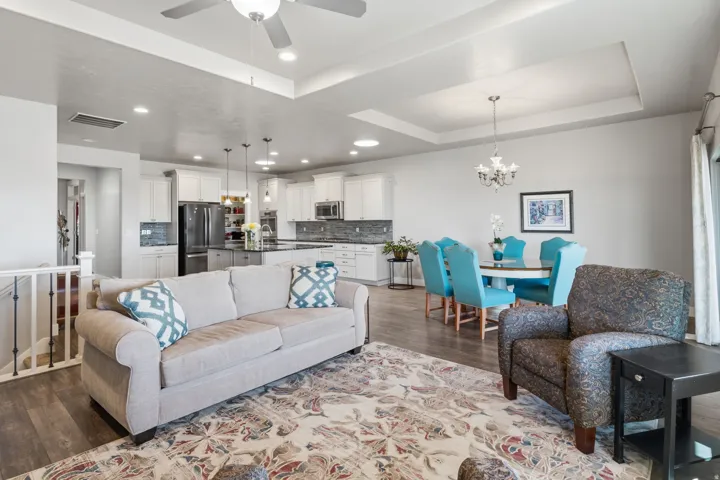 Open-concept living area with beautiful wood-finish flooring, a stone-surround fireplace with a white mantel.