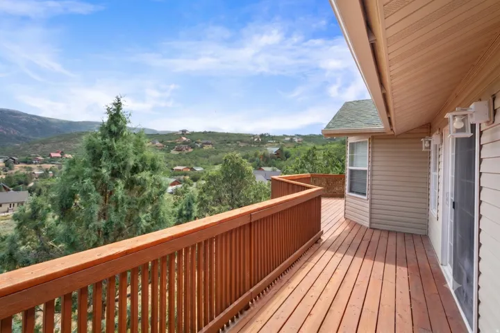 Expansive wood deck featuring natural wood railing and a bay window