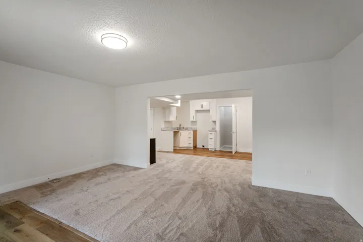 Spacious interior featuring neutral carpet, white walls, and a contemporary flush-mount ceiling light