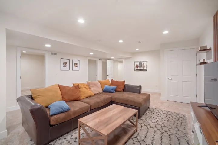 Spacious living area featuring recessed lighting, light neutral wall tones, and plush carpet flooring
