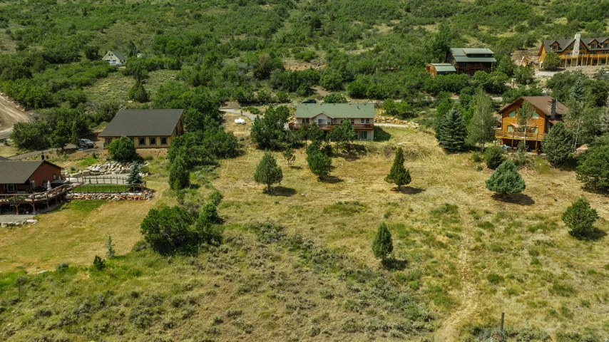 Expansive hillside property featuring multiple residences amidst natural landscaping
