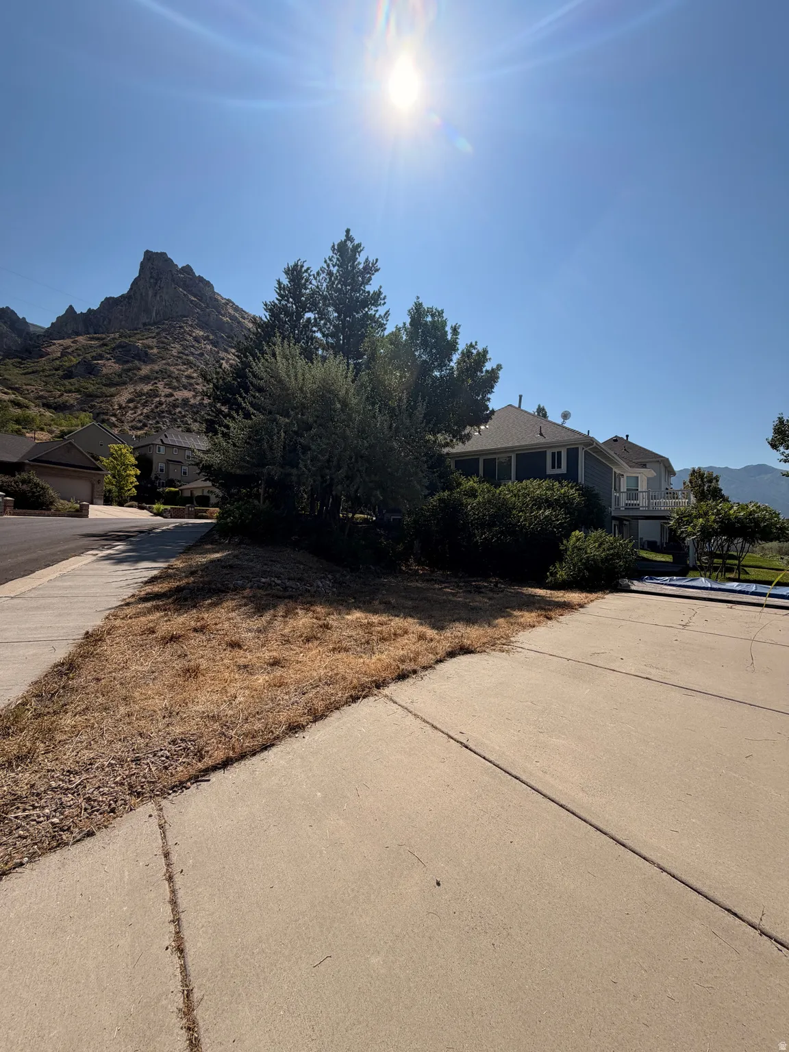 Concrete driveway and sidewalk with a mountainous backdrop