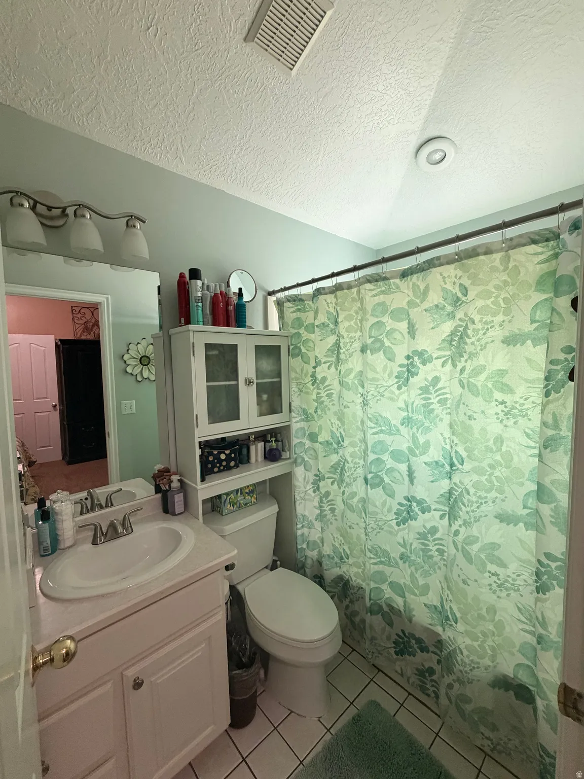 Bathroom featuring a vanity with an integrated sink, a toilet, and a shower/tub combination