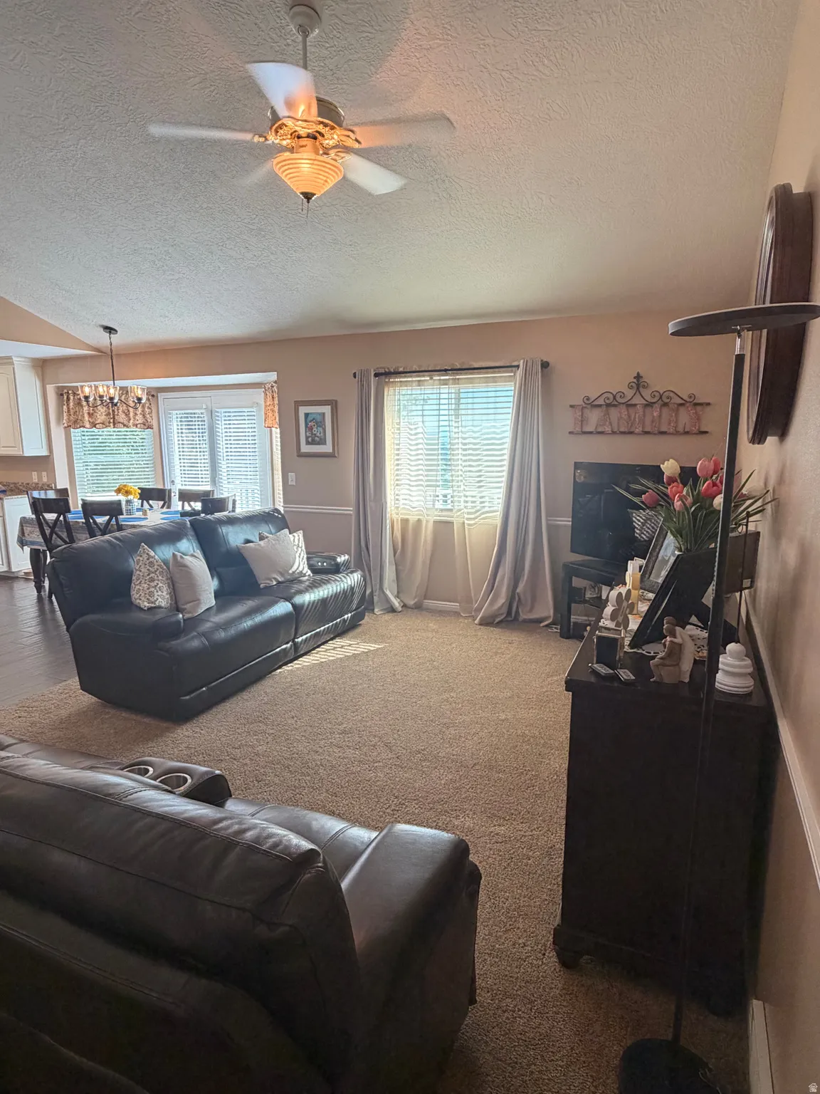 Open-concept living space featuring neutral tone wall paint and textured carpeting