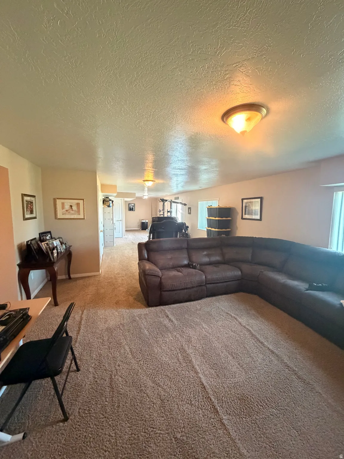 Spacious interior with neutral-toned walls and textured ceiling