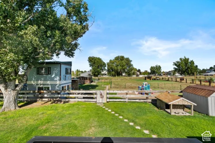 Expansive backyard featuring a manicured lawn, established shade tree, and wooden fence