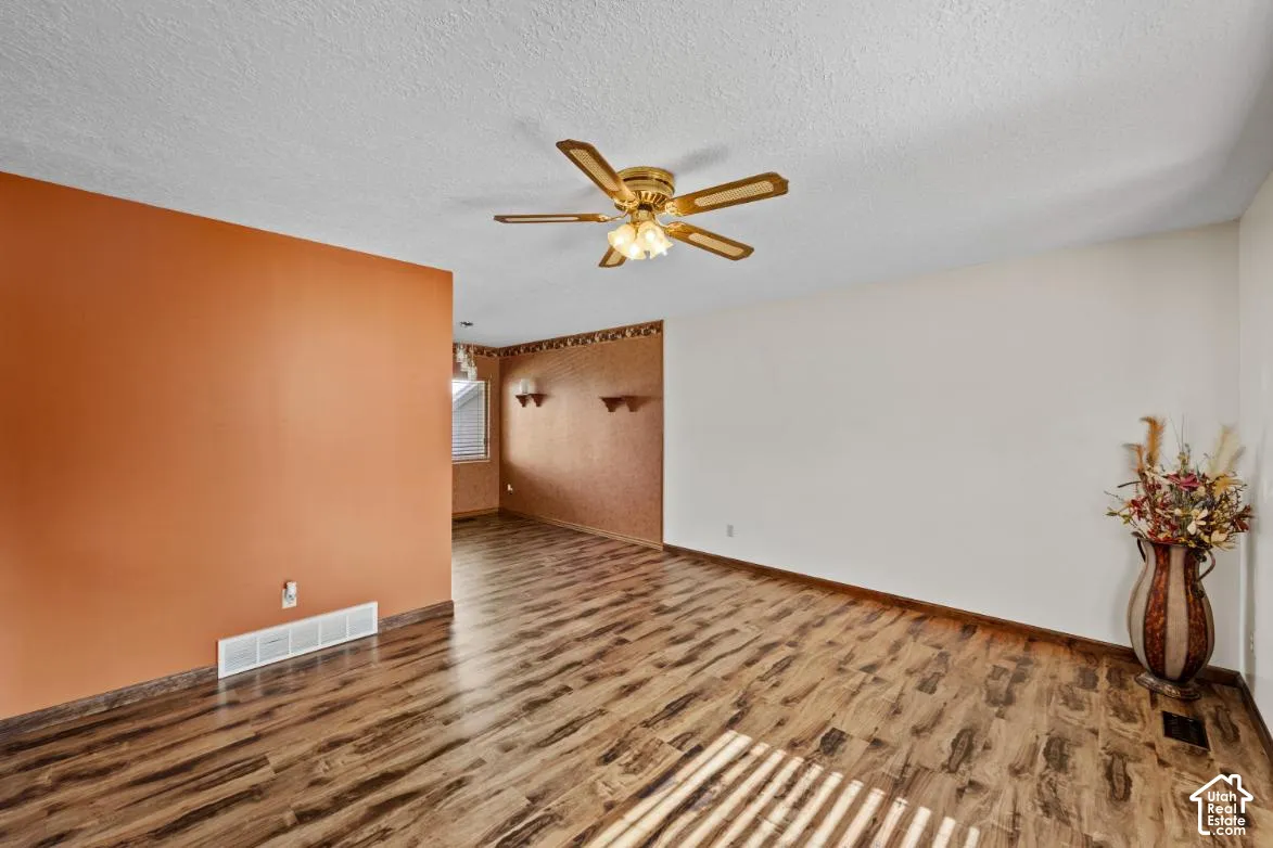 Wood-finish flooring throughout, complemented by a ceiling fan with integrated lighting