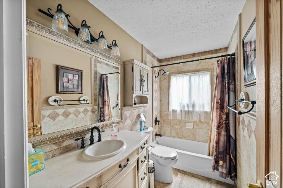 Spa-inspired bathroom featuring a ceramic pedestal sink with oil-rubbed bronze fixtures, ceramic tile backsplash with decorative border detailing, and a combined shower-tub enclosure with tile surround and coordinating curtain rod