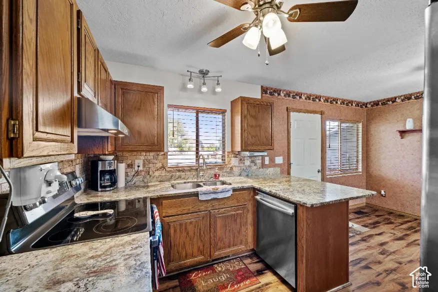 Spacious kitchen featuring warm wood cabinetry, granite countertops, stainless steel appliances, a center island with additional storage, and tile flooring