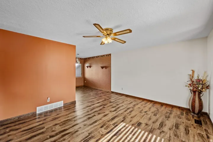Wood-finish flooring throughout, complemented by a ceiling fan with integrated lighting