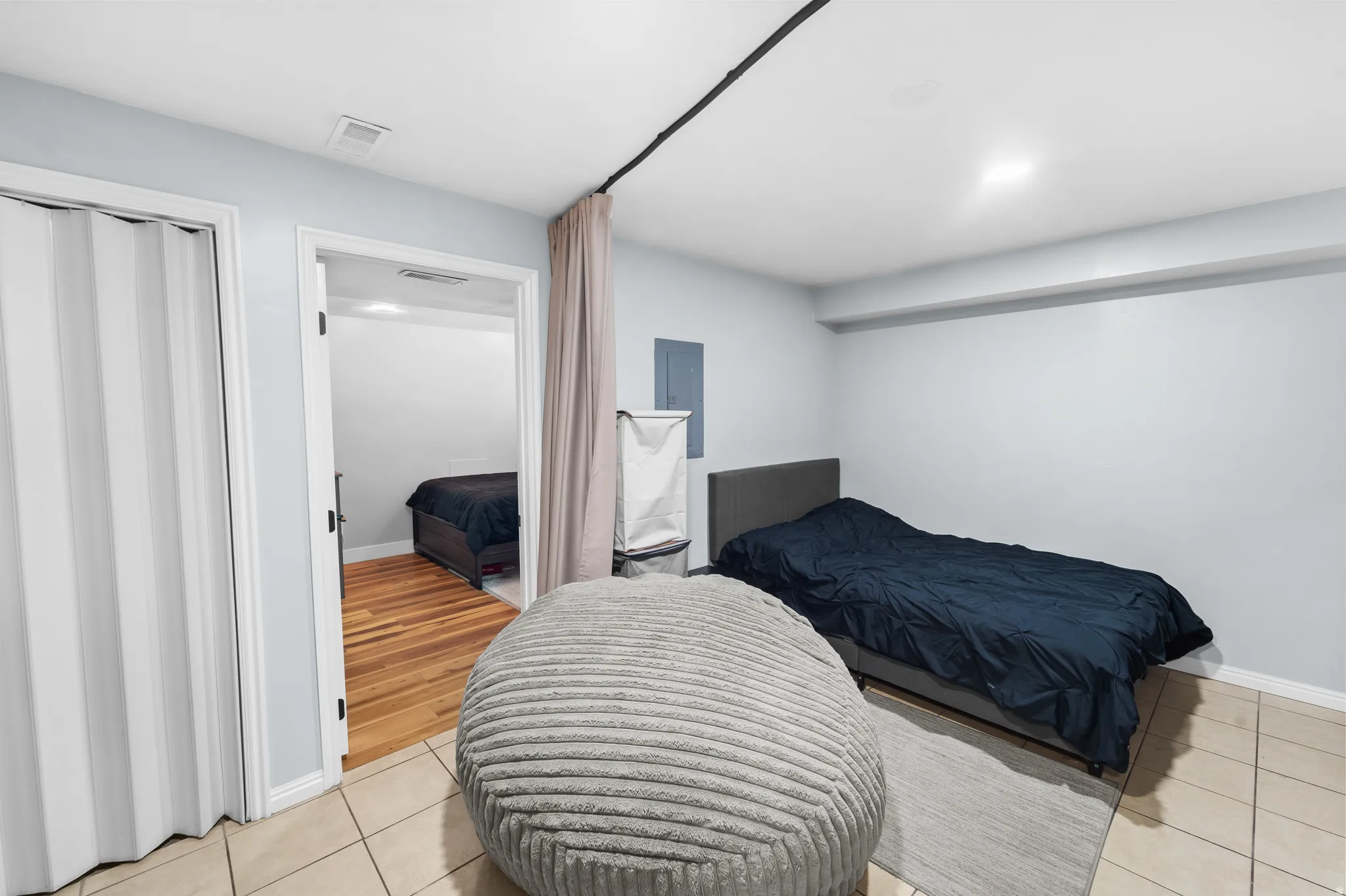 Tiled flooring with a gray area rug, light gray walls, and recessed lighting